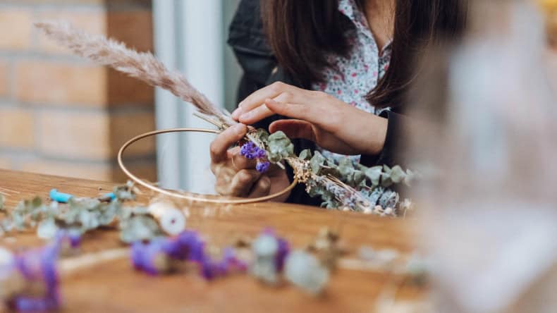 Frau beim Kranz binden