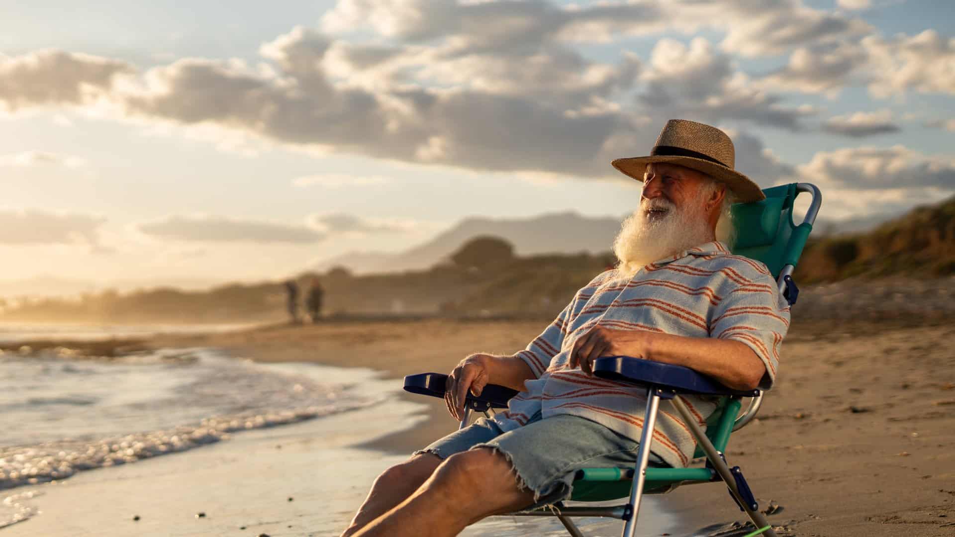 Älterer Mann im Stuhl am Strand, Meer, Dünen