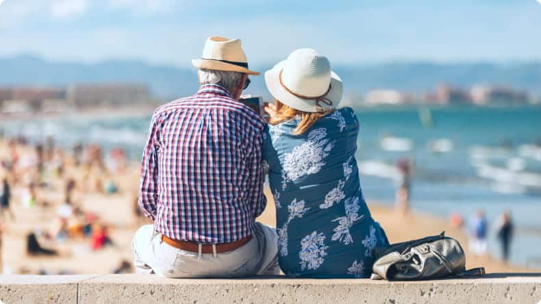 Älteres Paar sitzt am Strand