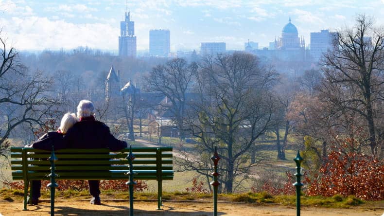 Älteres Paar sitzt auf Bank im Park