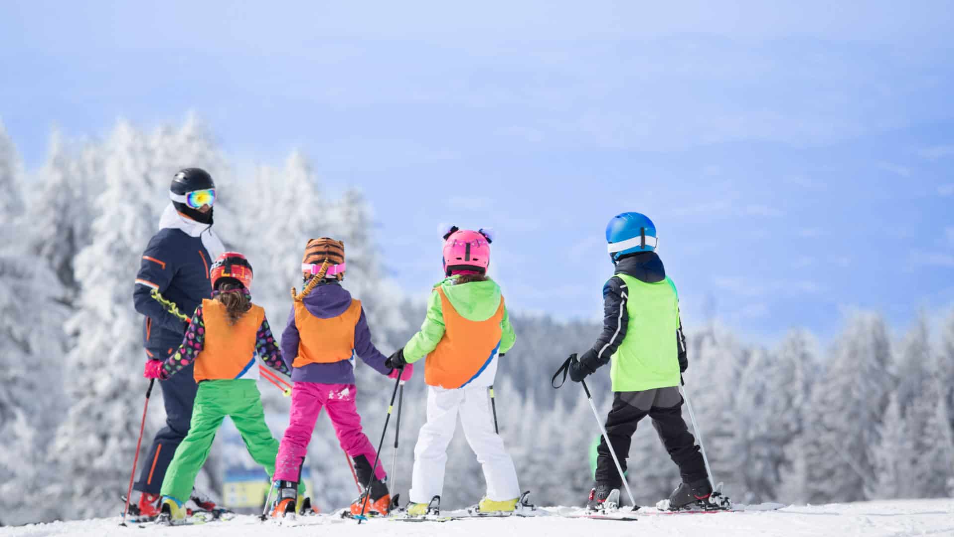 Skilehrer mit Skischülern beim Skifahren