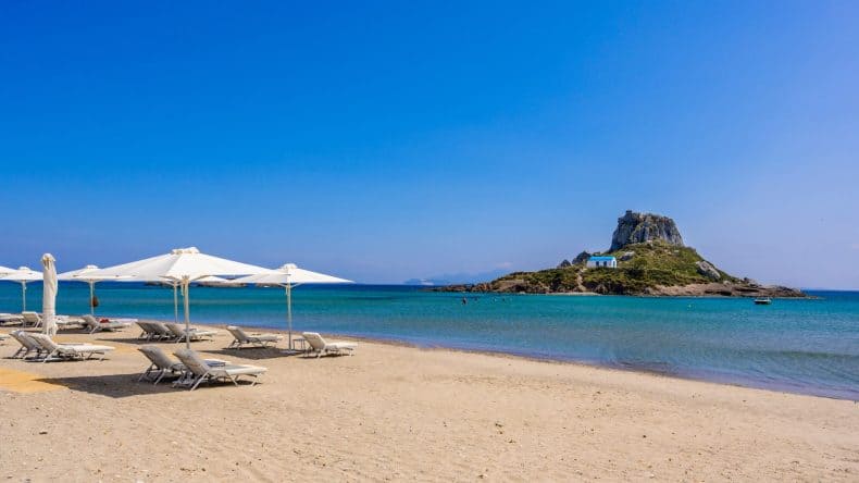 Der Agios Stefanos Beach mit Blick auf die Insel Kastri auf der griechischen Insel Kos.