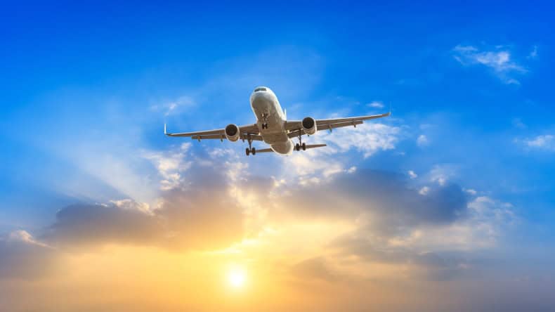 Flugzeug am Himmel bei Sonnenaufgang.