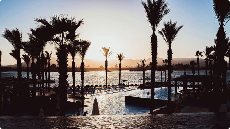 Sonnenuntergang am Strand mit Palmen in Ägypten