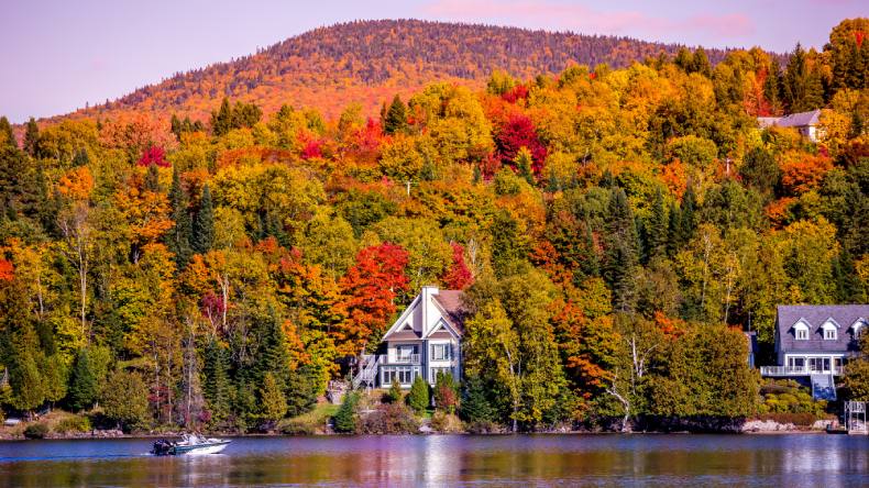 Blick auf farbenfrohe Wälder und ein Haus am See, Quebec, Kanada